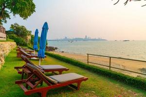 cadeiras de praia com o fundo do mar na hora do pôr do sol em Pattaya, Tailândia foto