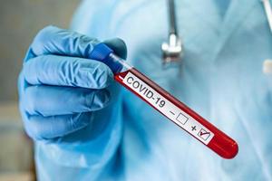 amostra de infecção de sangue positiva em tubo de ensaio para coronavírus covid-19 em laboratório. cientista segurando para verificar e analisar o paciente no hospital. foto