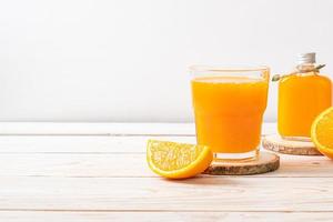 Copo de suco de laranja fresco com fundo de madeira foto