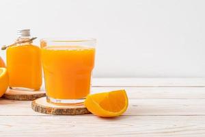 Copo de suco de laranja fresco com fundo de madeira foto