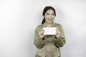 uma feliz jovem lindo ásia trabalhador vestindo Castanho uniforme segurando a envelope. indonésio pns conceito. foto