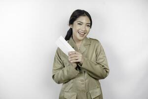 uma feliz jovem lindo ásia trabalhador vestindo Castanho uniforme segurando a envelope. indonésio pns conceito. foto