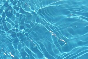azul água com ondulações em a superfície. desfocar borrado transparente azul colori Claro calma água superfície textura com salpicos e bolhas. água ondas com brilhando padronizar textura fundo. foto