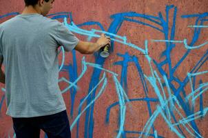 kharkov, ucrânia - 27 de maio de 2017 festival de artes de rua. jovens desenham grafite em paredes de madeira portáteis no centro da cidade. o processo de pintura em paredes com latas de aerossol foto