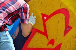kharkov, ucrânia - 27 de maio de 2017 festival de artes de rua. jovens desenham grafite em paredes de madeira portáteis no centro da cidade. o processo de pintura em paredes com latas de aerossol foto