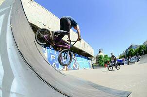 kharkiv, ucrânia - 27 de maio de 2018 pilotos de bmx freestyle em um skatepark durante o festival anual de culturas de rua foto