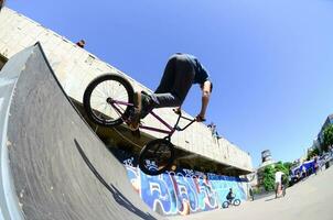 kharkiv, ucrânia - 27 de maio de 2018 pilotos de bmx freestyle em um skatepark durante o festival anual de culturas de rua foto