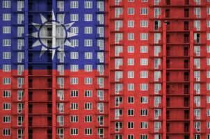 Taiwan bandeira retratado dentro pintura cores em de vários andares residente construção debaixo construção. texturizado bandeira em tijolo parede fundo foto