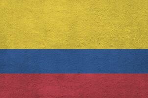 bandeira da colômbia retratada em cores brilhantes de tinta na parede de reboco em relevo antigo. banner texturizado em fundo áspero foto