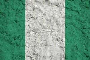 bandeira da nigéria retratada em cores de tinta brilhante na parede de reboco em relevo antigo. banner texturizado em fundo áspero foto