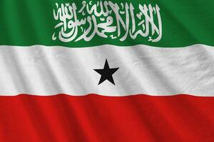 bandeira da somalilândia com grandes dobras acenando de perto sob a luz do estúdio dentro de casa. os símbolos oficiais e cores no banner foto