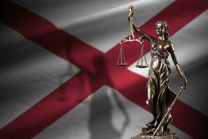 Alabama nos Estado bandeira com estátua do senhora justiça e judicial balanças dentro Sombrio sala. conceito do julgamento e punição foto