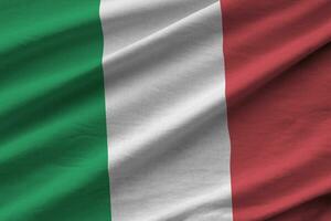 bandeira da itália com grandes dobras acenando de perto sob a luz do estúdio dentro de casa. os símbolos oficiais e cores no banner foto