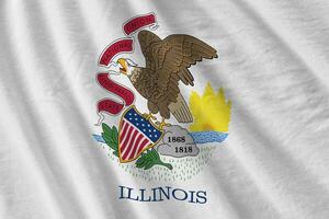 bandeira do estado de Illinois com grandes dobras acenando de perto sob a luz do estúdio dentro de casa. os símbolos oficiais e cores no banner foto