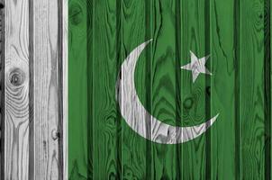 bandeira do paquistão retratada em cores de tinta brilhante na parede de madeira velha. banner texturizado em fundo áspero foto