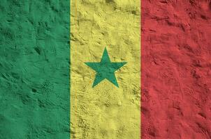 bandeira do senegal retratada em cores de tinta brilhante na parede de reboco em relevo antigo. banner texturizado em fundo áspero foto