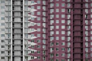 Catar bandeira retratado dentro pintura cores em de vários andares residente construção debaixo construção. texturizado bandeira em tijolo parede fundo foto