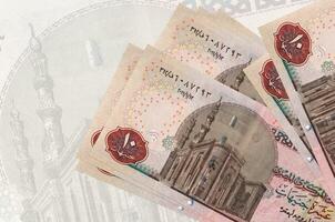 Notas de 10 libras egípcias estão na pilha no fundo da grande nota semitransparente. apresentação abstrata da moeda nacional foto