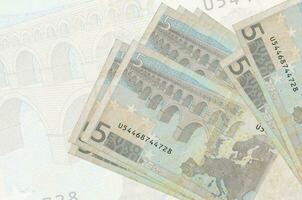 Notas de 5 euros estão na pilha no fundo da grande nota semitransparente. apresentação abstrata da moeda nacional foto