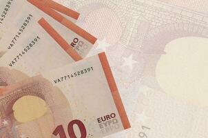 As notas de 10 euros estão empilhadas no fundo de uma grande nota semitransparente. plano de fundo abstrato do negócio foto