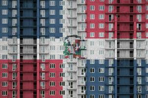 dominicano república bandeira retratado dentro pintura cores em de vários andares residente construção debaixo construção. texturizado bandeira em tijolo parede fundo foto