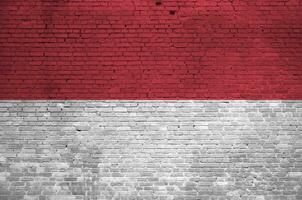 Indonésia bandeira retratado dentro pintura cores em velho tijolo muro. texturizado bandeira em grande tijolo parede alvenaria fundo foto