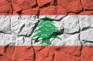 Líbano bandeira retratado dentro pintura cores em velho pedra parede fechar-se. texturizado bandeira em Rocha parede fundo foto