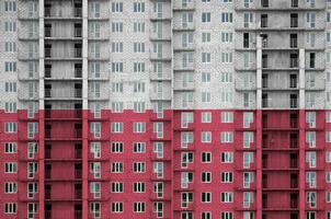 Polônia bandeira retratado dentro pintura cores em de vários andares residente construção debaixo construção. texturizado bandeira em tijolo parede fundo foto