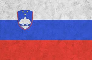 bandeira da eslovênia retratada em cores de tinta brilhantes na parede de reboco em relevo antigo. banner texturizado em fundo áspero foto