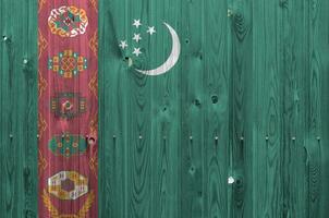 bandeira do turquemenistão retratada em cores de tinta brilhante na parede de madeira velha. banner texturizado em fundo áspero foto