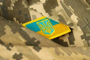 tecido de camuflagem militar com bandeira ucraniana em chevron uniforme foto
