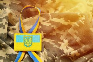 tecido de camuflagem militar com bandeira ucraniana em chevron uniforme foto