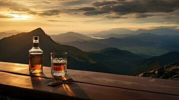 uma uísque vidro e uma garrafa em uma Barra mesa dentro a fundo estão montanhas e uma mar do névoa às pôr do sol. foto