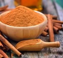 paus de canela e canela em pó na tigela sobre a mesa foto