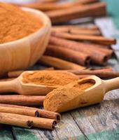 paus de canela e canela em pó na tigela sobre a mesa foto