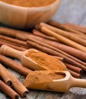 paus de canela e canela em pó na tigela sobre a mesa foto