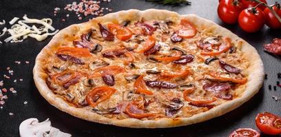 deliciosa pizza fresca feita em forno de lenha com tomate, linguiça e cogumelos foto