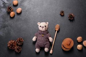 urso de brinquedo amarrado com fios de lã em um fundo escuro foto