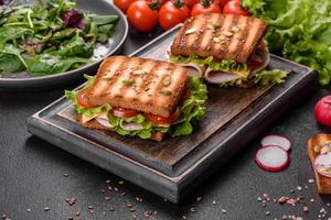 delicioso sanduíche com torradas crocantes, presunto, alface e tomate foto