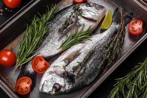 peixe dourado cru com especiarias, cozinhando na tábua. peixe fresco dourado foto