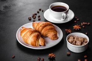 Crocante fresco e delicioso croissant francês com uma xícara de café perfumado