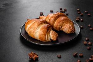 Crocante fresco e delicioso croissant francês com uma xícara de café perfumado foto