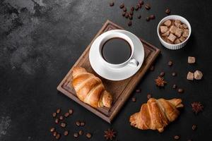 Crocante fresco e delicioso croissant francês com uma xícara de café perfumado foto