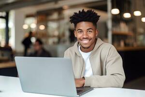 retrato do alegre Preto masculino aluna Aprendendo conectados dentro café comprar, jovem africano americano homem estudos com computador portátil dentro cafeteria, fazendo dever de casa foto