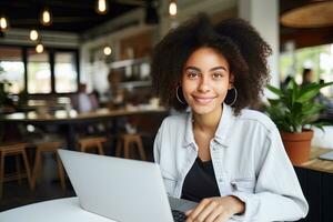 retrato do lindo Preto fêmea aluna Aprendendo conectados dentro café comprar, jovem africano americano mulher estudos com computador portátil dentro cafeteria, fazendo dever de casa foto