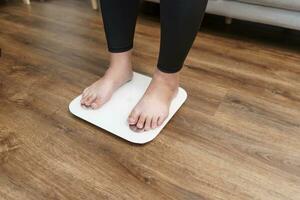 gordo dieta e escala pés em pé em eletrônico balanças para peso ao controle. medição instrumento dentro quilograma para uma dieta ao controle. foto