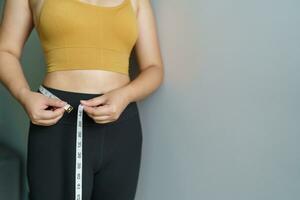 mulher quer para perder peso com uma centímetro forma acima saudável estômago músculo e dieta medindo cintura com a medida fita depois de dieta peso ao controle foto