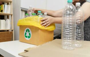 casa reciclar eco verde zero conceito mulher jogando esvaziar plástico garrafa dentro reciclando bin com amarelo lixo bolsas às lar. foto