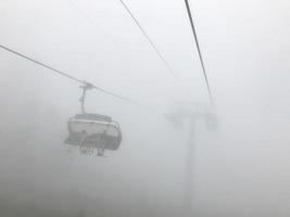 o teleférico no meio do nevoeiro. montanhas do cáucaso. área de sochi, Rússia foto