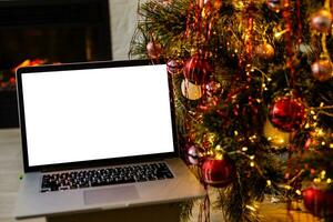 laptop com fundo de caixa de presente e luzes de natal foto